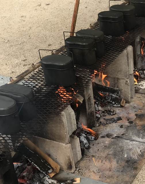 焚き火の上にかけられた飯盒でお米を炊いているところ
