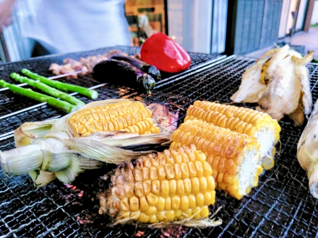 BBQの網でとうもろこしと野菜を焼いているところ