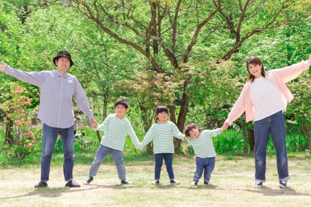 手をつないで歩く家族