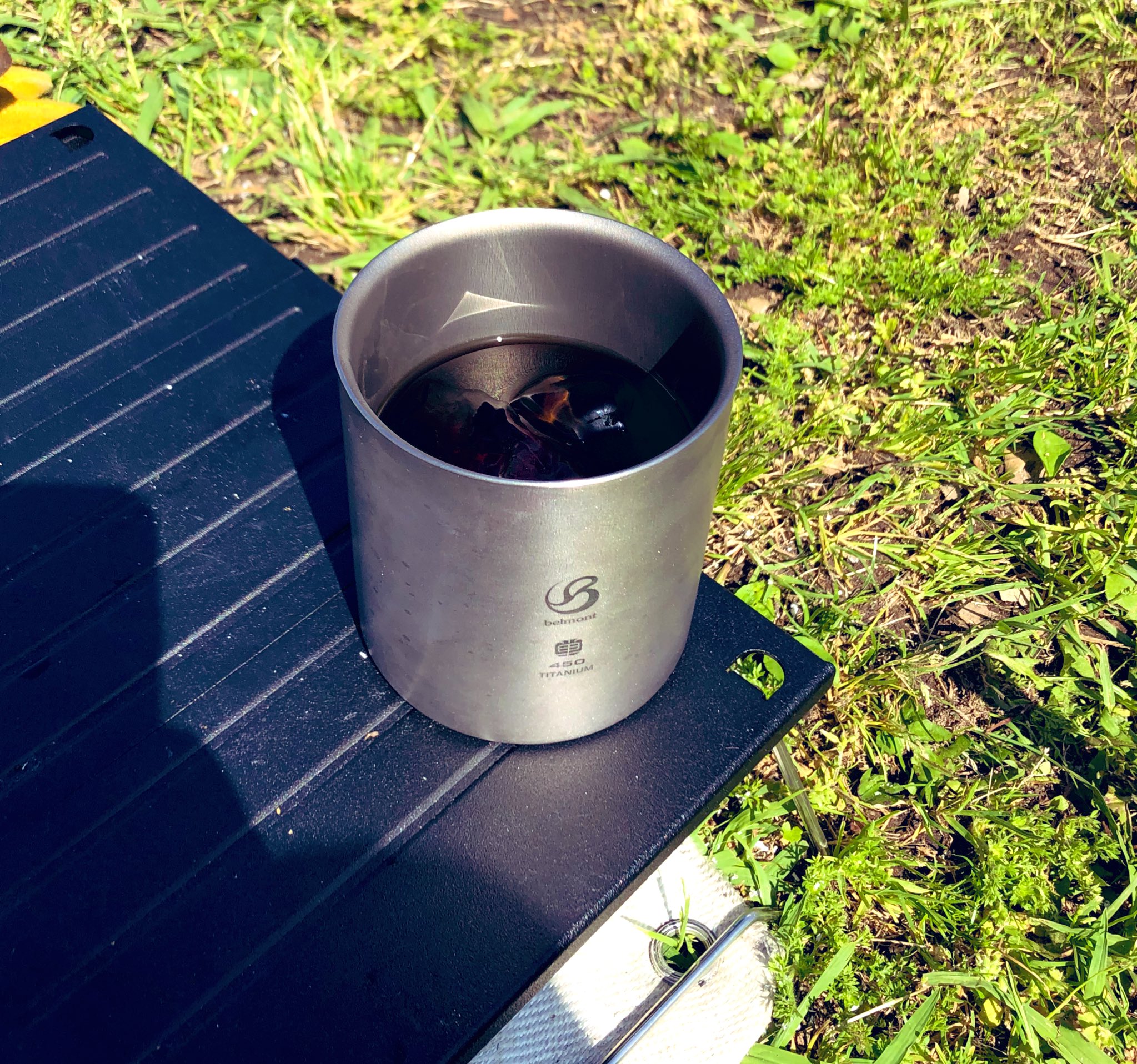 屋外で飲むチタンマグのコーヒー