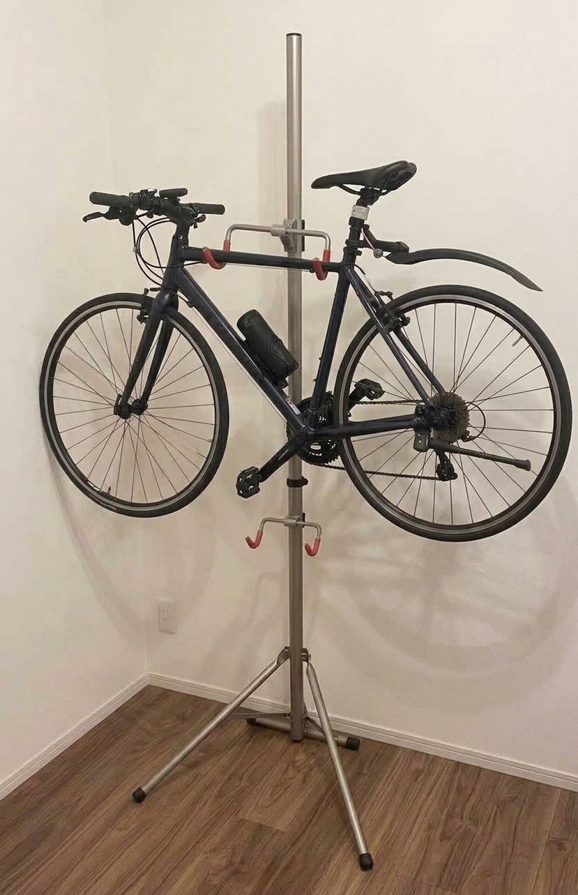 支柱を立てるタイプのスタンドで、部屋のすみに吊るして保管しているクロスバイク