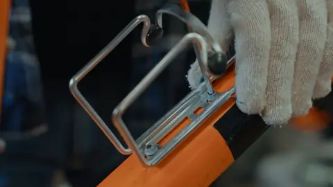 自転車のフレームにボトルケージをネジでとめているところ