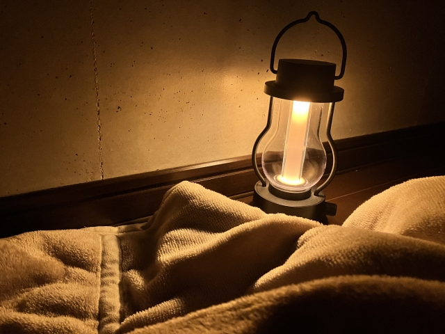寝床の横で、電球色にやさしく灯るランタン型のLEDライト