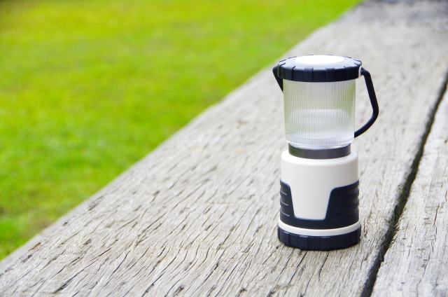木のベンチの上に置いた、白い筒形のLEDランタン